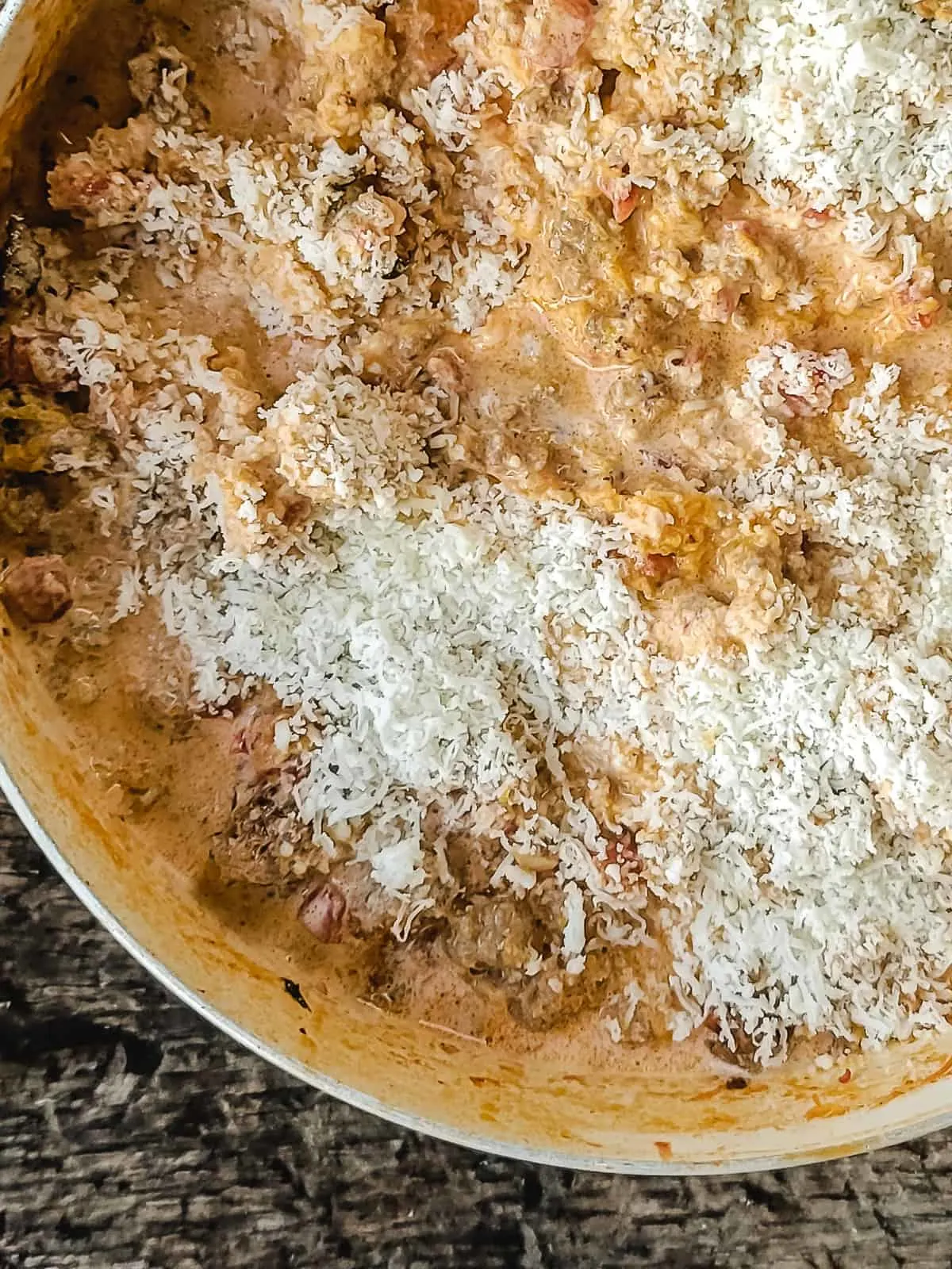 Creamy tomato sauce with ground sausage, sprinkled with Parmesan cheese.