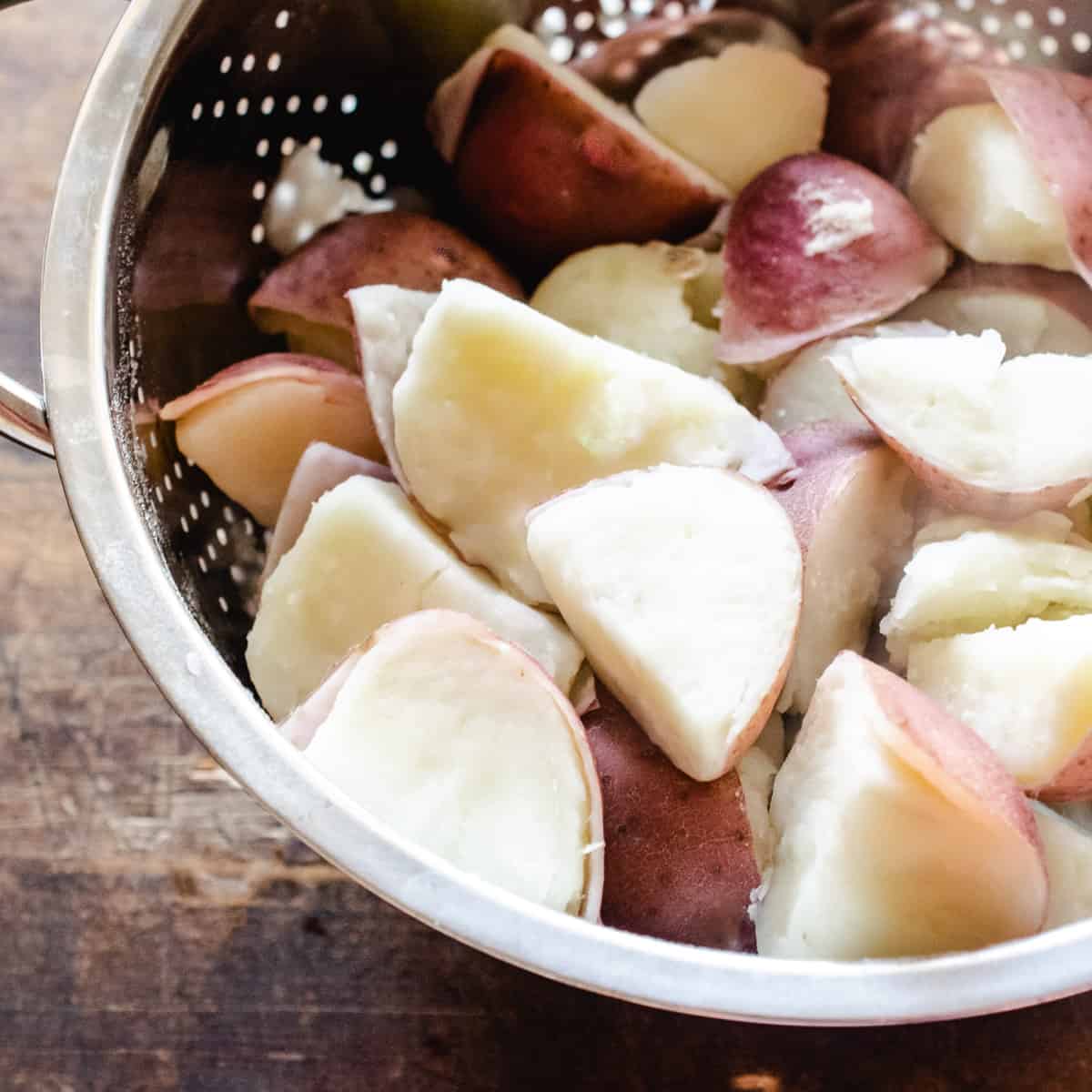 Boiled red potatoes in a strainer. 