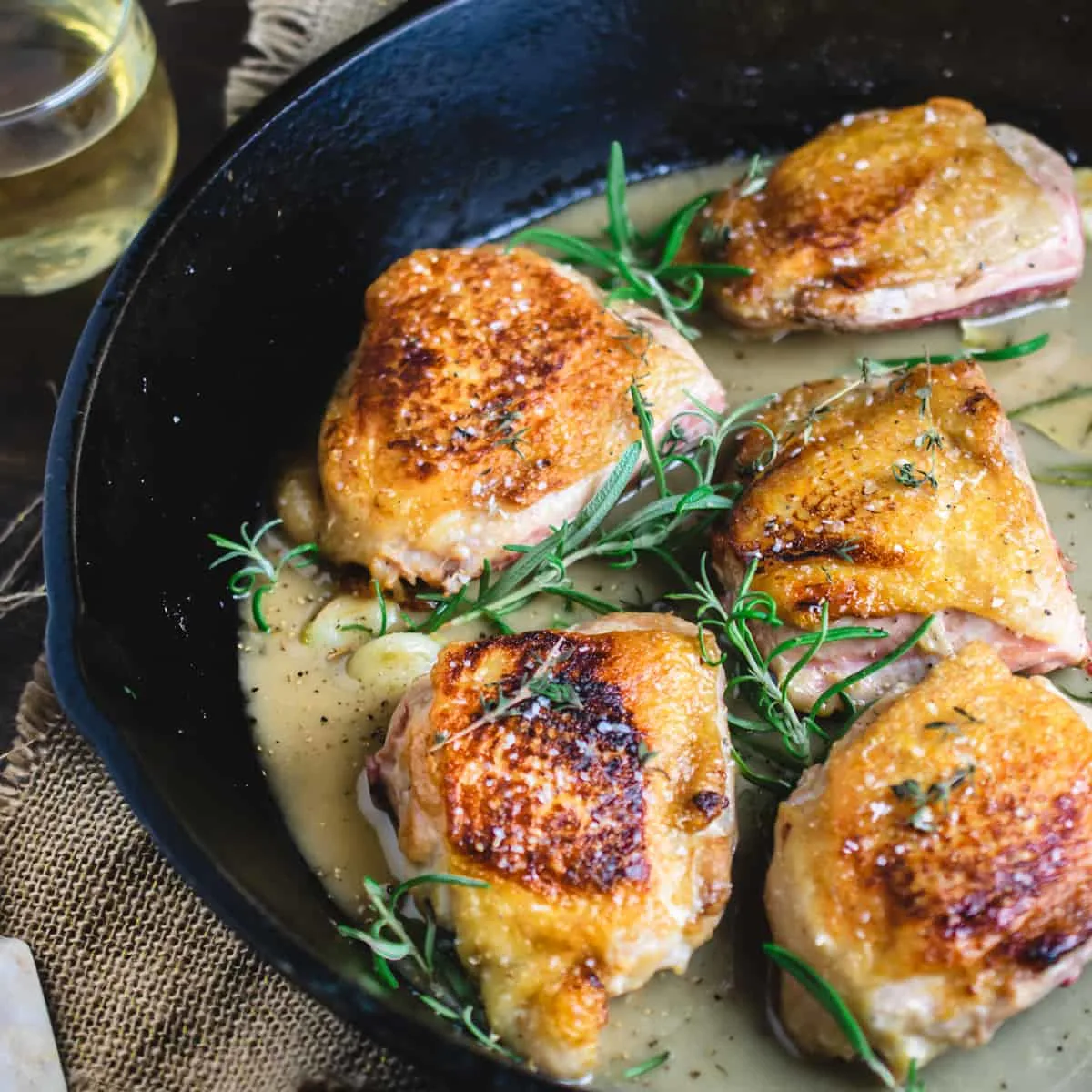 Skin on chicken with salt, herbs and a pan sauce in a cast iron skillet.