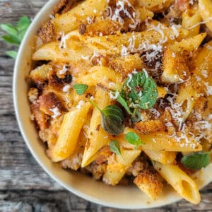 Bowl of pasta with vodka sauce, oregano, and croutons on top.