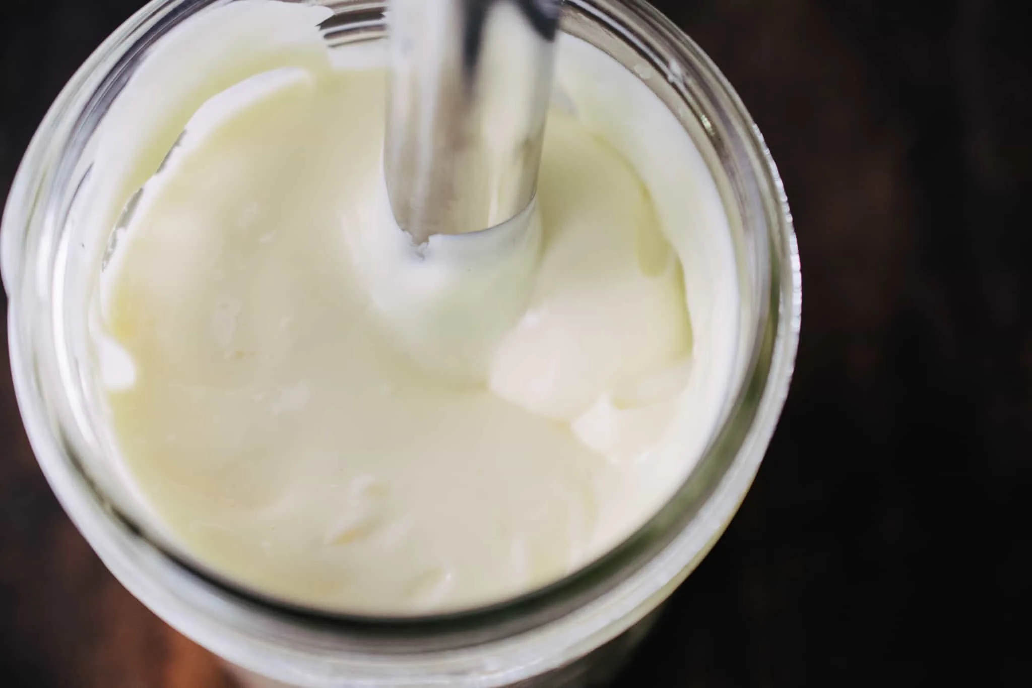 mason jar of homemade mayonnaise on wooden table 