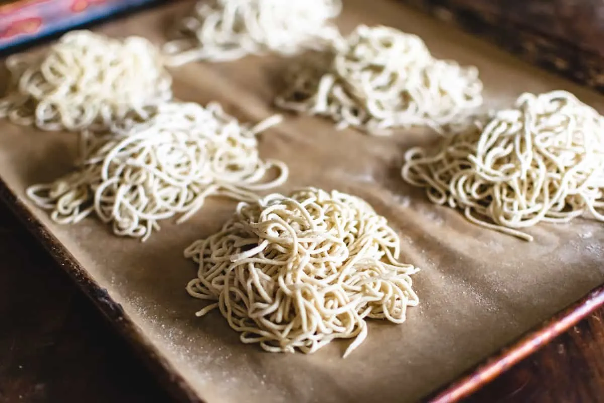 Piles of uncooked ramen noodles on a baking sheet.
