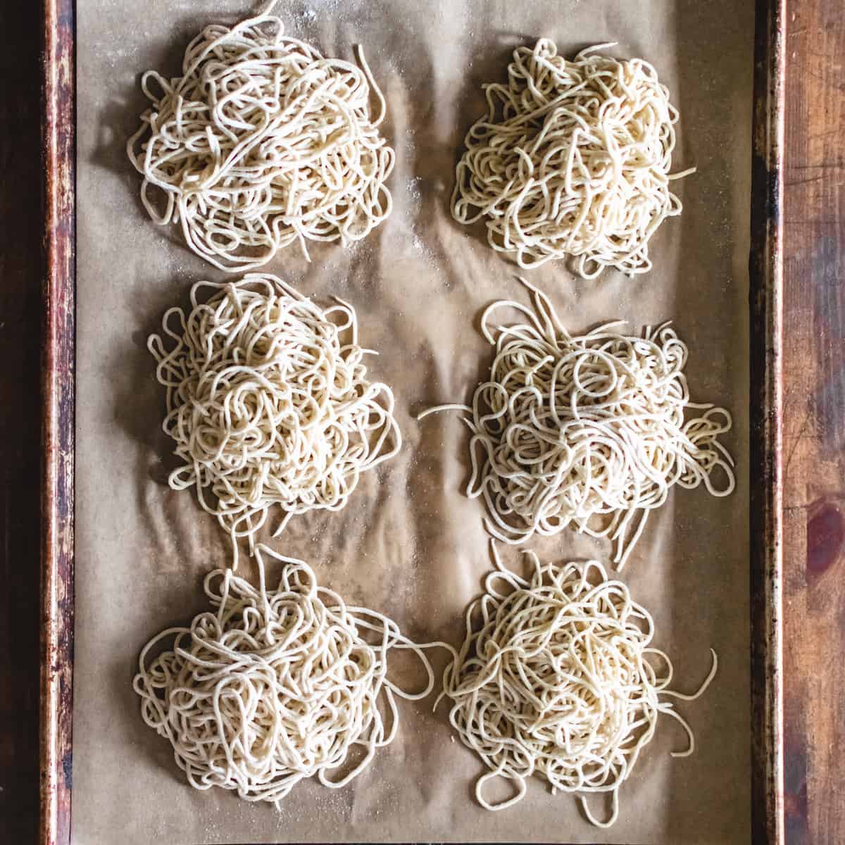 Piles of ramen noodles on parchment paper.