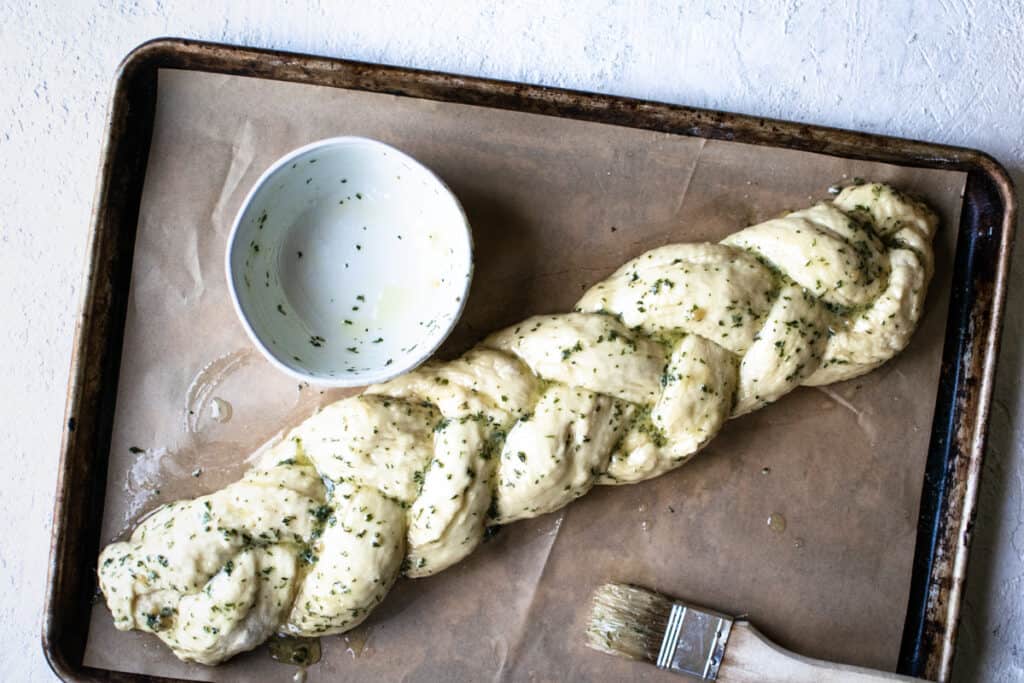 uncooked garlic knot bread with butter brushed over it