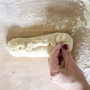 Bread roll being pinched at the seam.