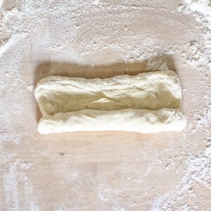 Dough being rolled into a tube.