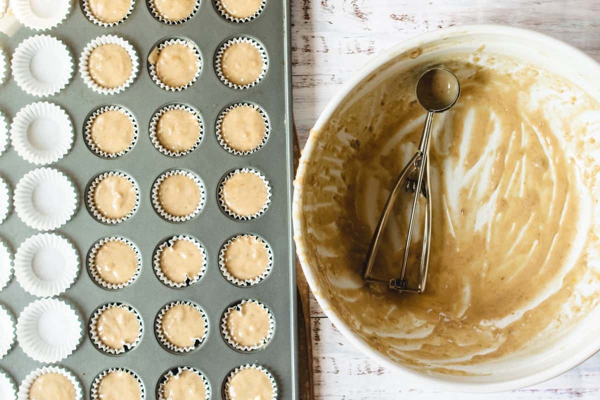 Banana bread batter scooped into a muffin tin.