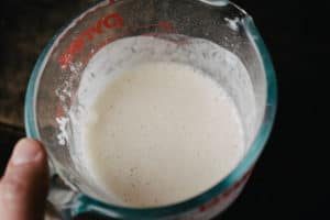 a glass pyrex liquid measuring cup with flour and water whisked together until smooth