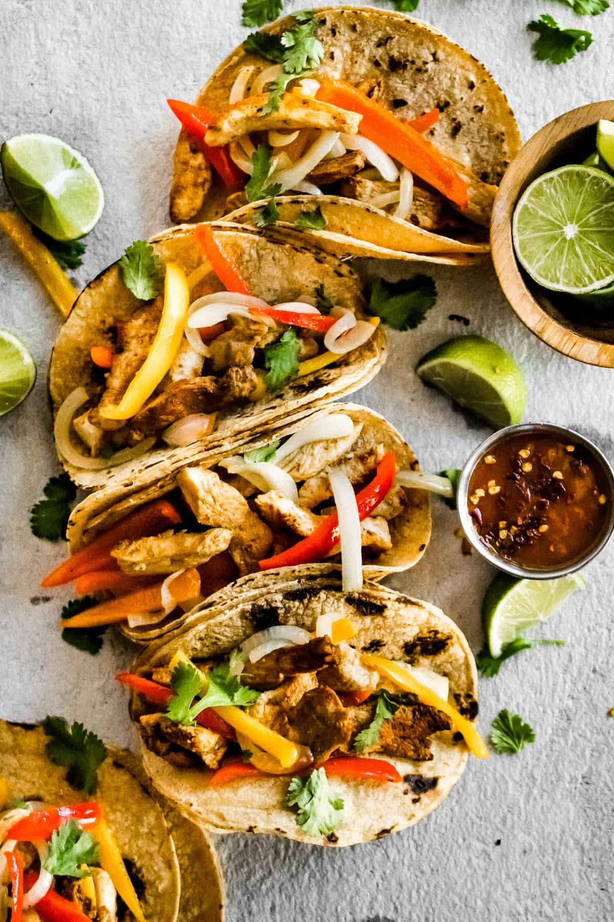 Corn tortillas filled with a mixture of grilled chicken, bell peppers, and onions. 