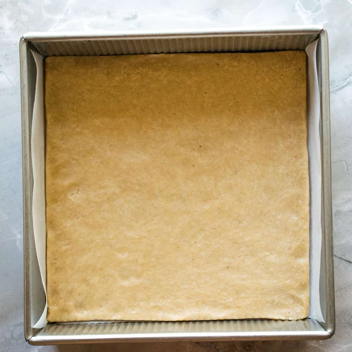 Cinnamon crust dough pressed into the bottom of a square pan. 