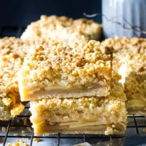 A stack of square apple crumb bars with streusel crumb topping