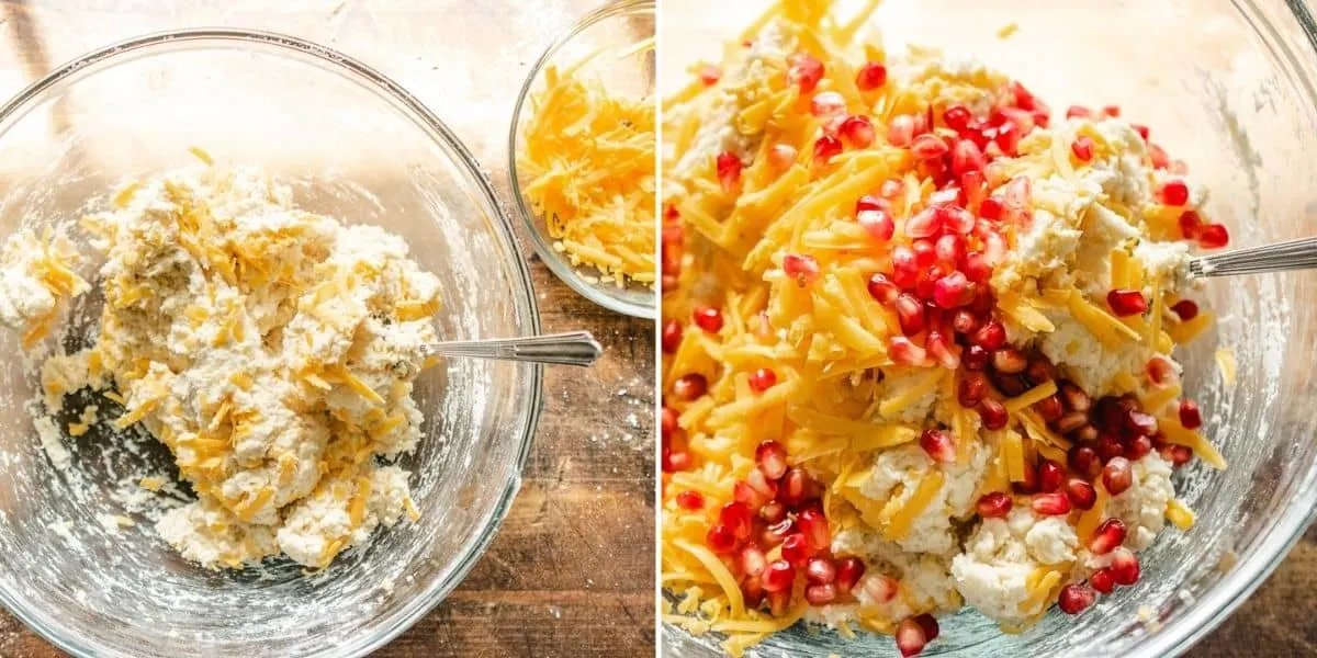 Shredded cheese and pomegranate seeds added to biscuit dough in a bowl.
