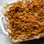 casserole in a white dish with a golden crunchy cracker crumb topping on white background