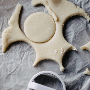 Round circles cut in sugar cookie dough with a biscuit cutter.