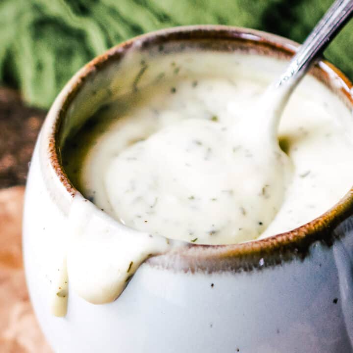 Homemade Buttermilk Ranch Dressing in a cup with a spoon.