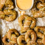 Baking sheet with soft pretzels and bowl of beer cheese.
