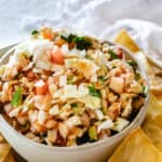 small bowl of cabbage salsa in front of white towel with tortilla chips