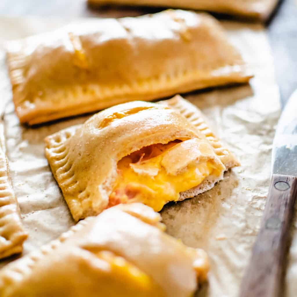 Pastry pockets filled with melted cheese sauce and pieces of ham.