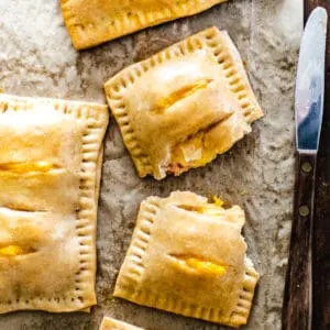 A ham and cheese filled pastry crust cut in half with a knife.