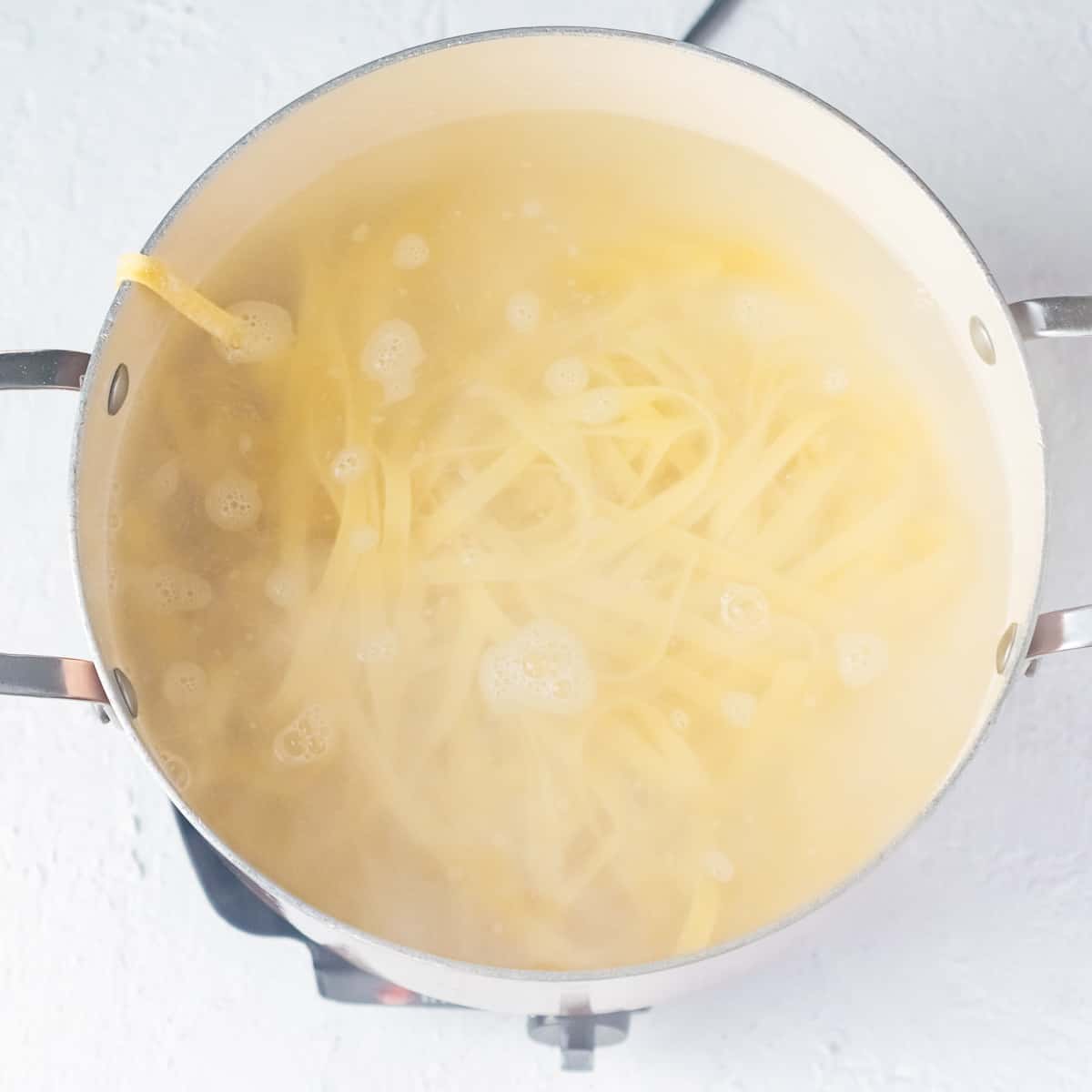 A large pot of boiling water with pasta.