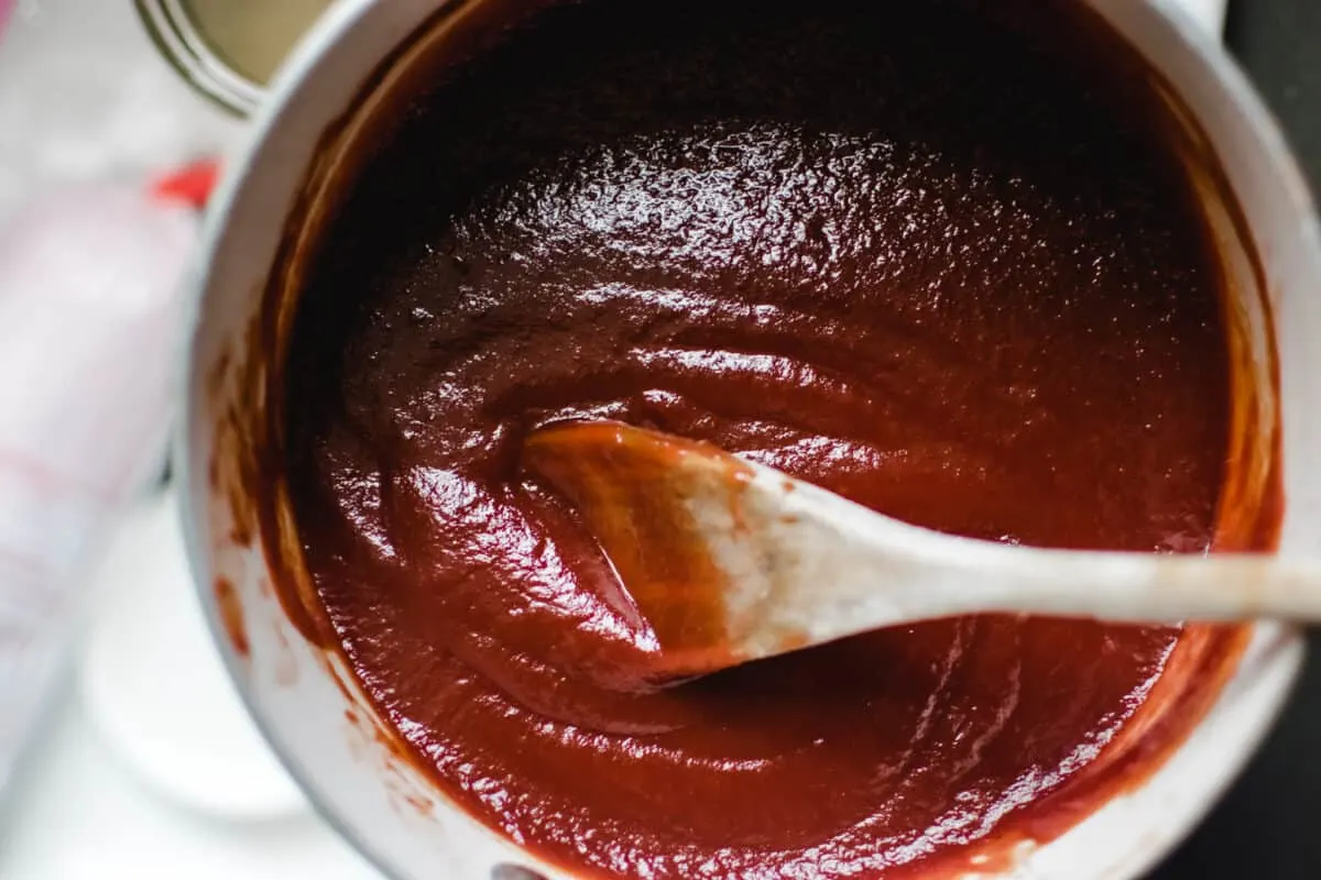 sauce pan of finished homemade ketchup with wooden spoon
