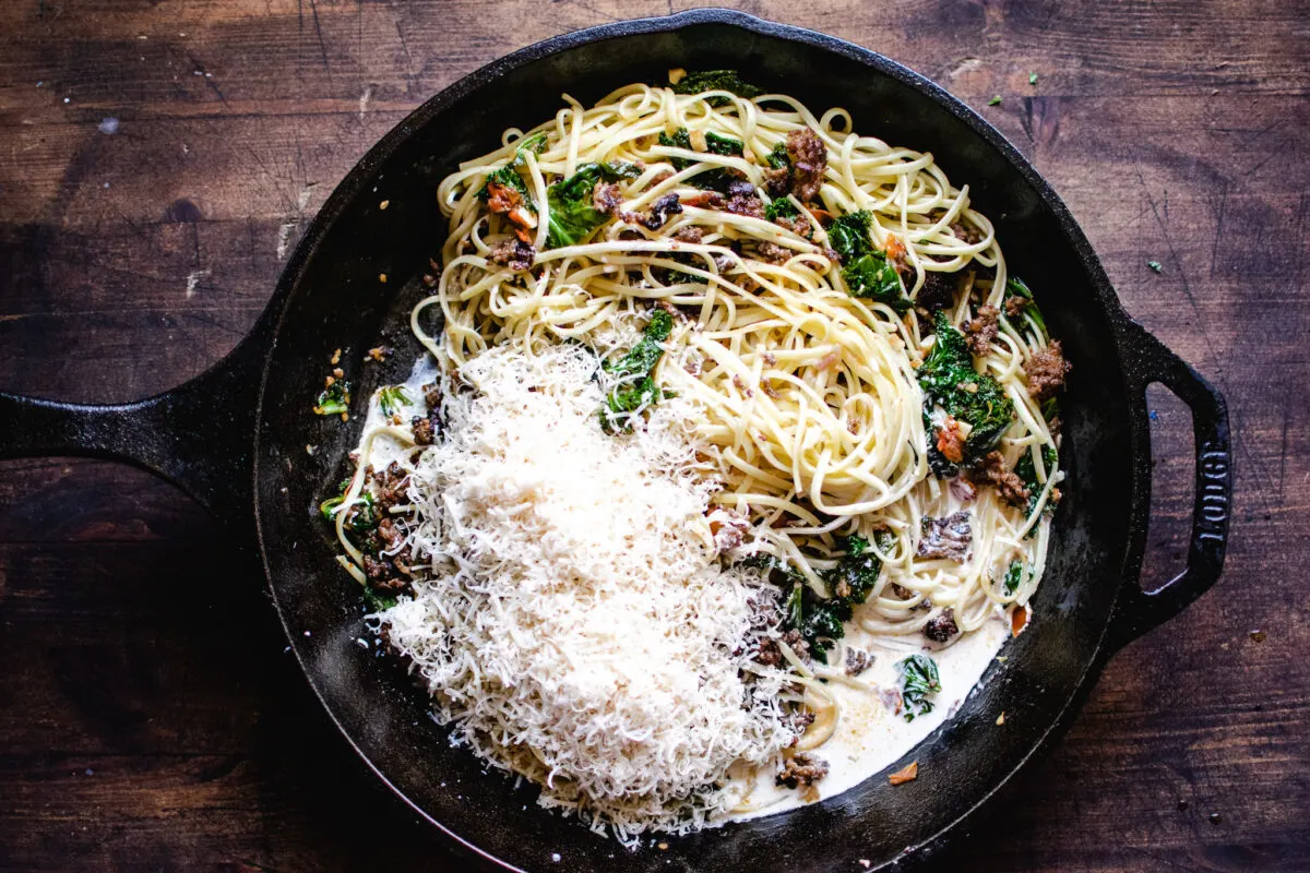 skillet of linguine, kale and sausage to be tossed with cream and Parmesan wine sauce