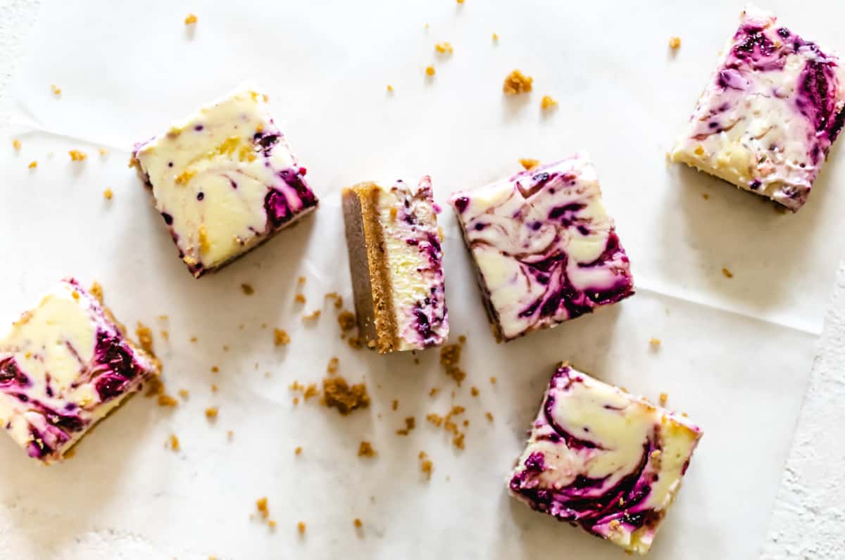 berry swirled cheesecake cut into bars