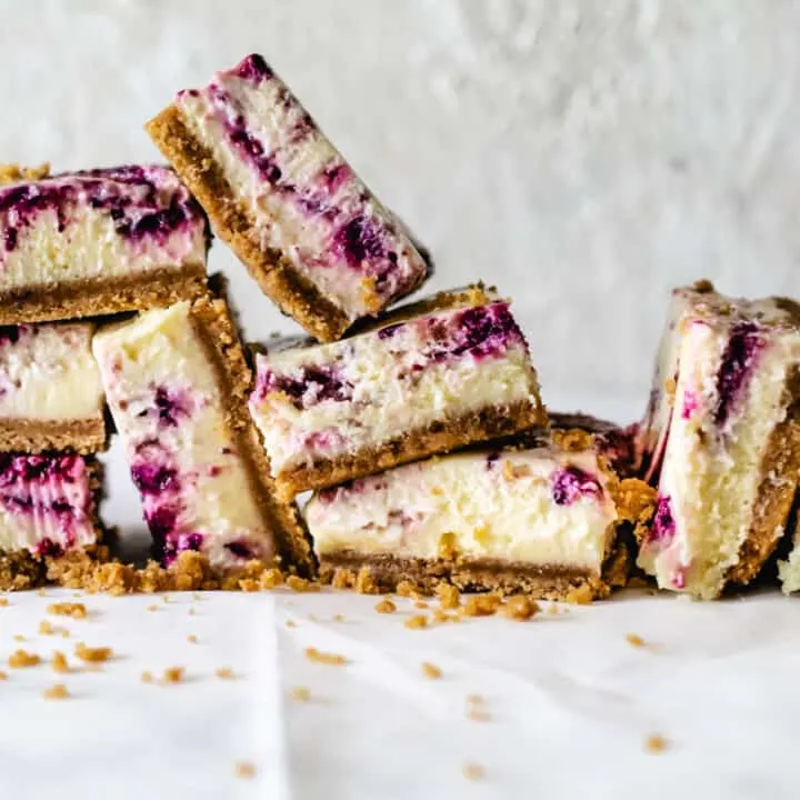 stack of cheesecake squared with berry swirls
