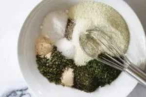 dry ranch mix ingredients in a white bowl with metal whisk