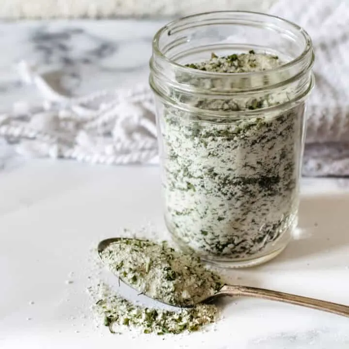 A mason jar of powdered ranch seasoning mix with a spoon.
