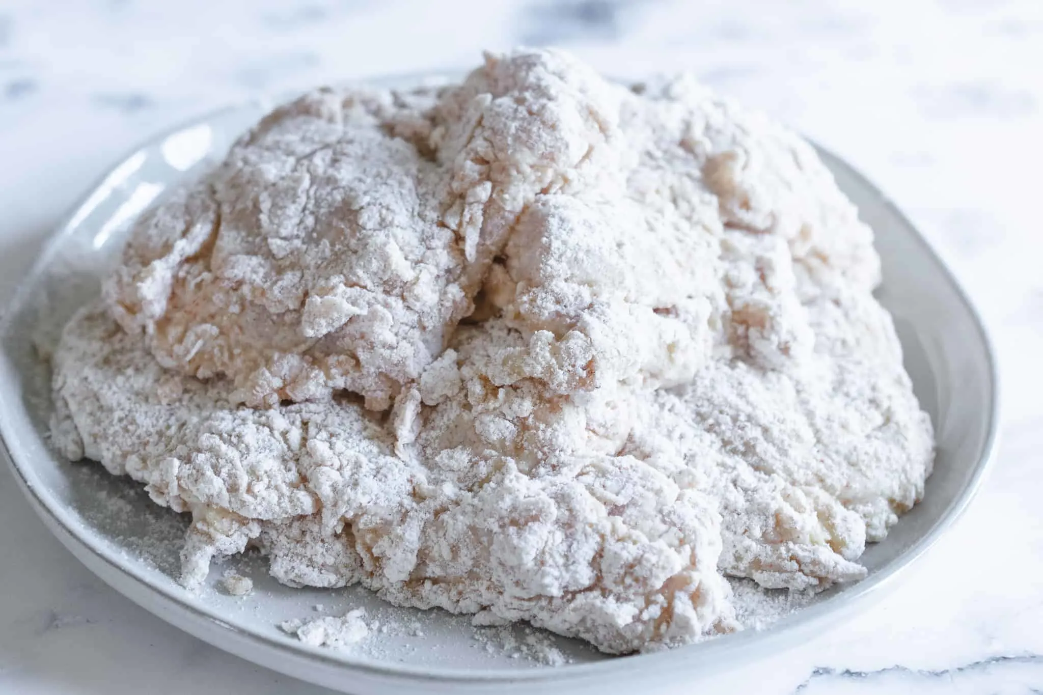 patties of chicken dredged in flour mixture stacked on a plate