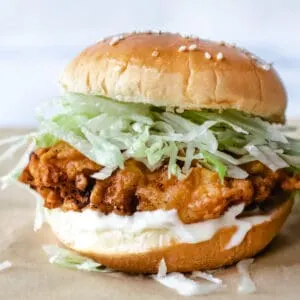 fried chicken patty with mayo and shredded ice burg lettuce on a sesame seed bun