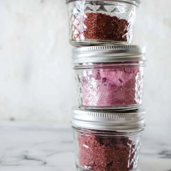 small mason jars filled with homemade fruit powder stacked up