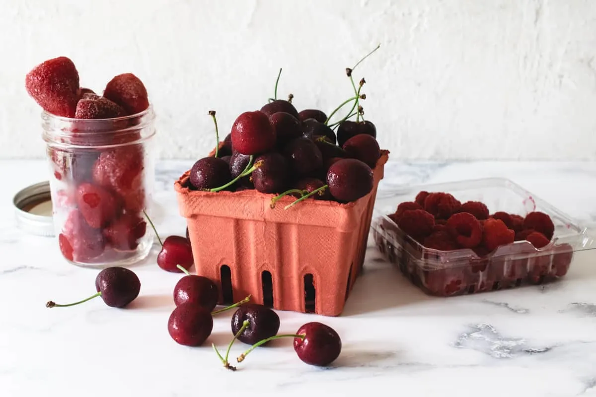 baskets and jars of fresh and frozen berries