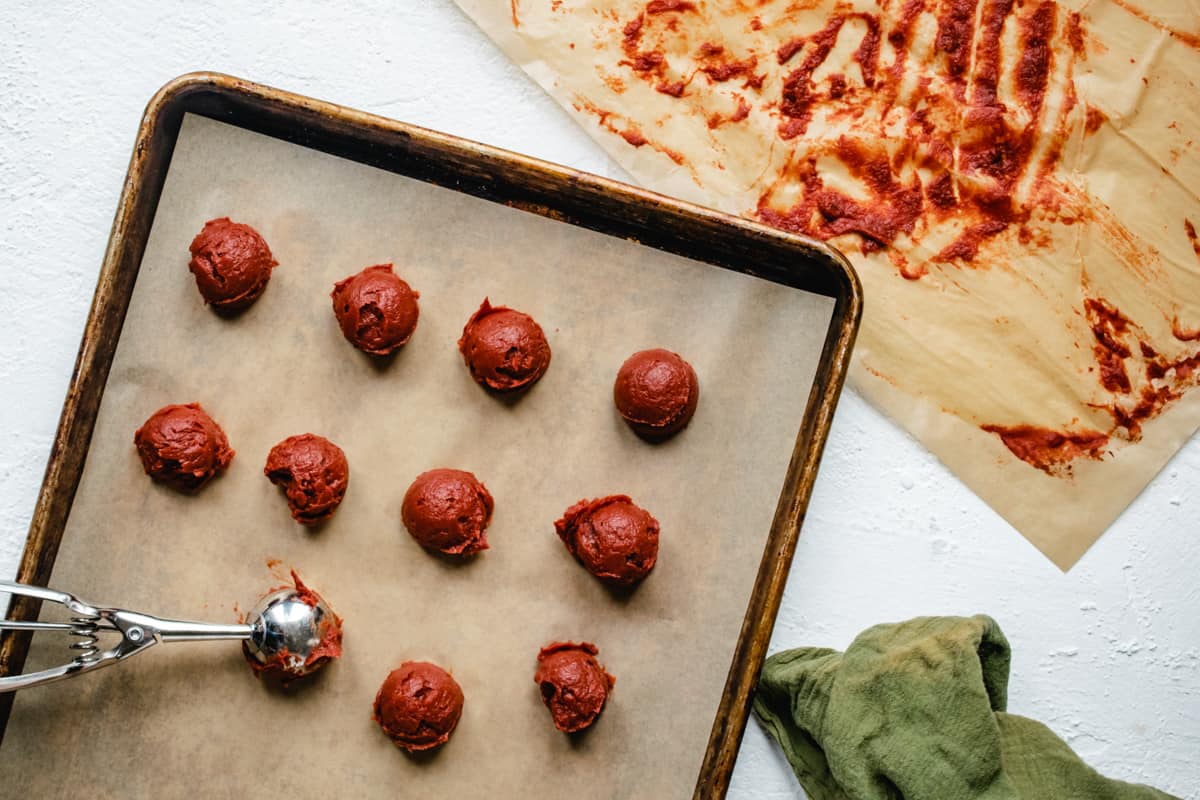 Scooping tomato paste onto a flat tray.