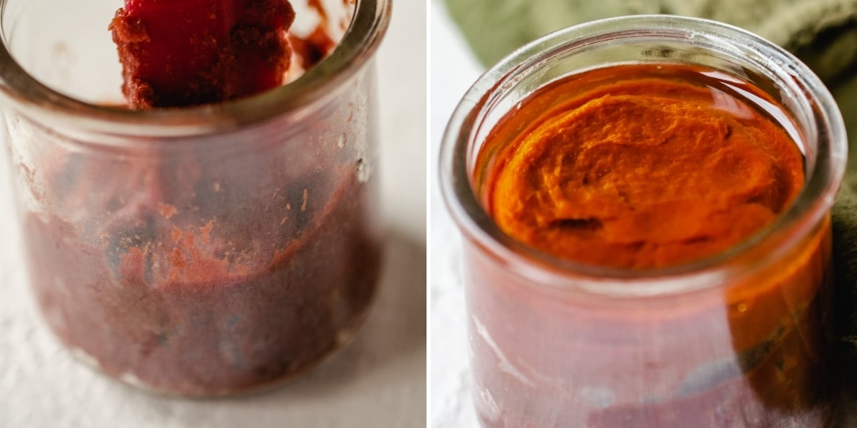 Packing tomato paste into a glass jar with a rubber spatula.