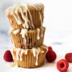 stack of three muffins drizzled with white chocolate and raspberries