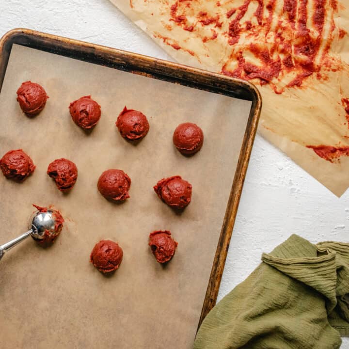 Scooping tomato paste onto a baking sheet.