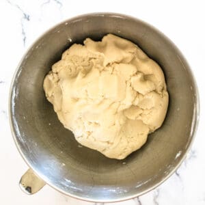 Ball of dough in a metal mixing bowl.
