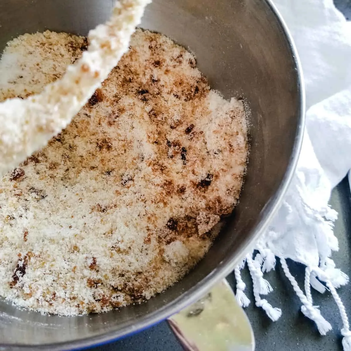 crumbles of white sugar and bits of molasses in a metal bowl