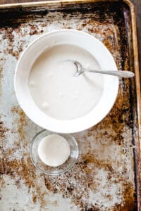 White icing in a small bowl and a large bowl.
