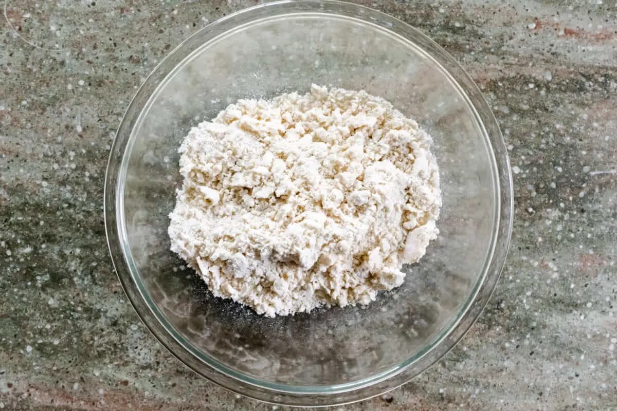 Bowl of dry pie crust ingredients with shortening cut in.