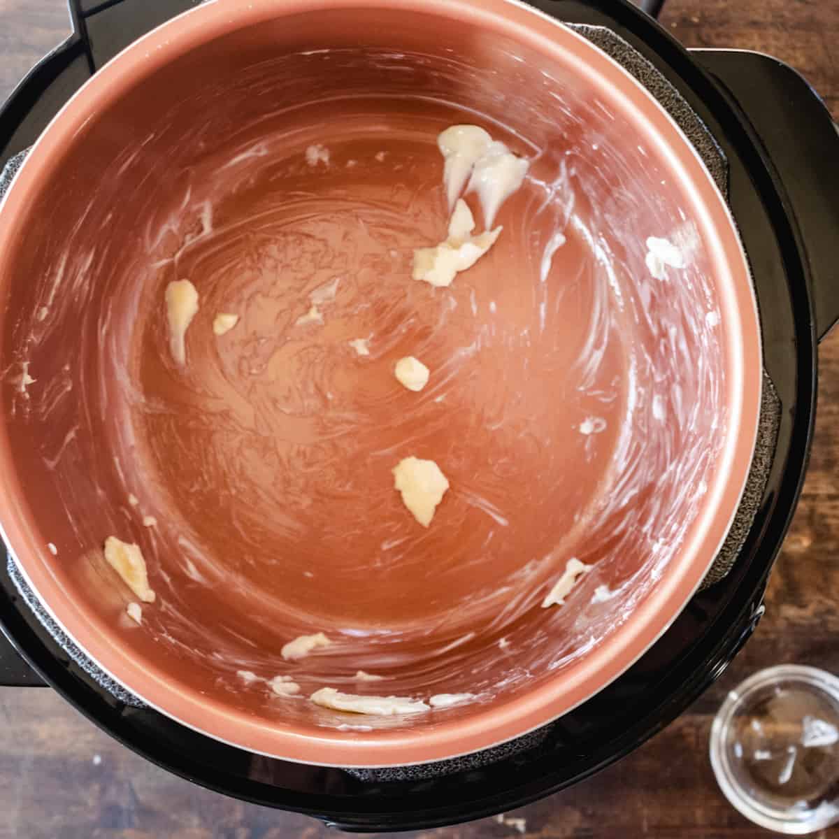 Empty pressure cooker pot rubbed with butter. 
