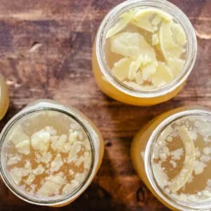 Bone broth in jars with solid fat pieces on top layer.
