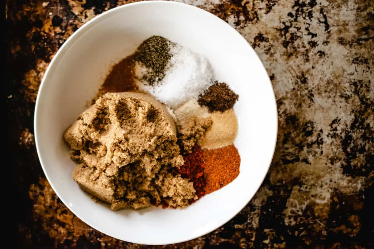 White bowl filled with dried spices and brown sugar.