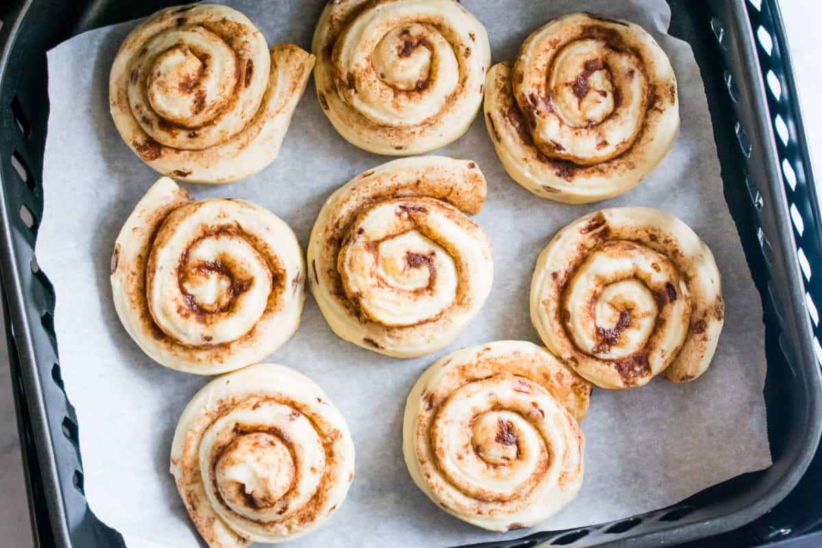 Cooked cinnamon rolls on parchment paper.