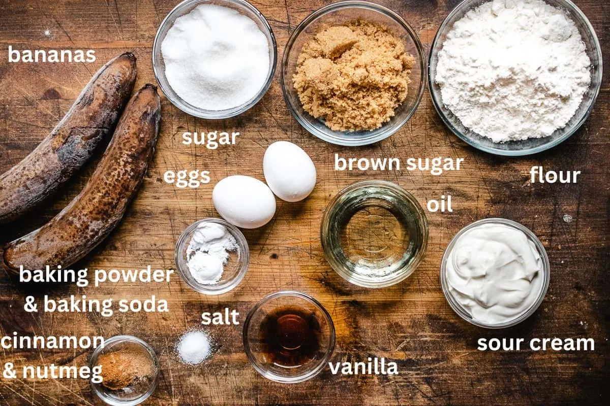Bananas, flour, sugar, brown sugar, eggs, vanilla, cinnamon, oil, nutmeg, sour cream, and salt. 
