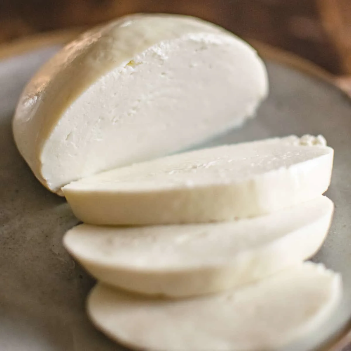 Sliced mozzarella cheese on a plate.