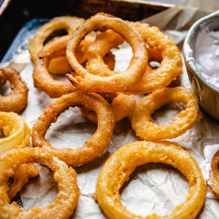 Gluten free onion rings on parchment paper.