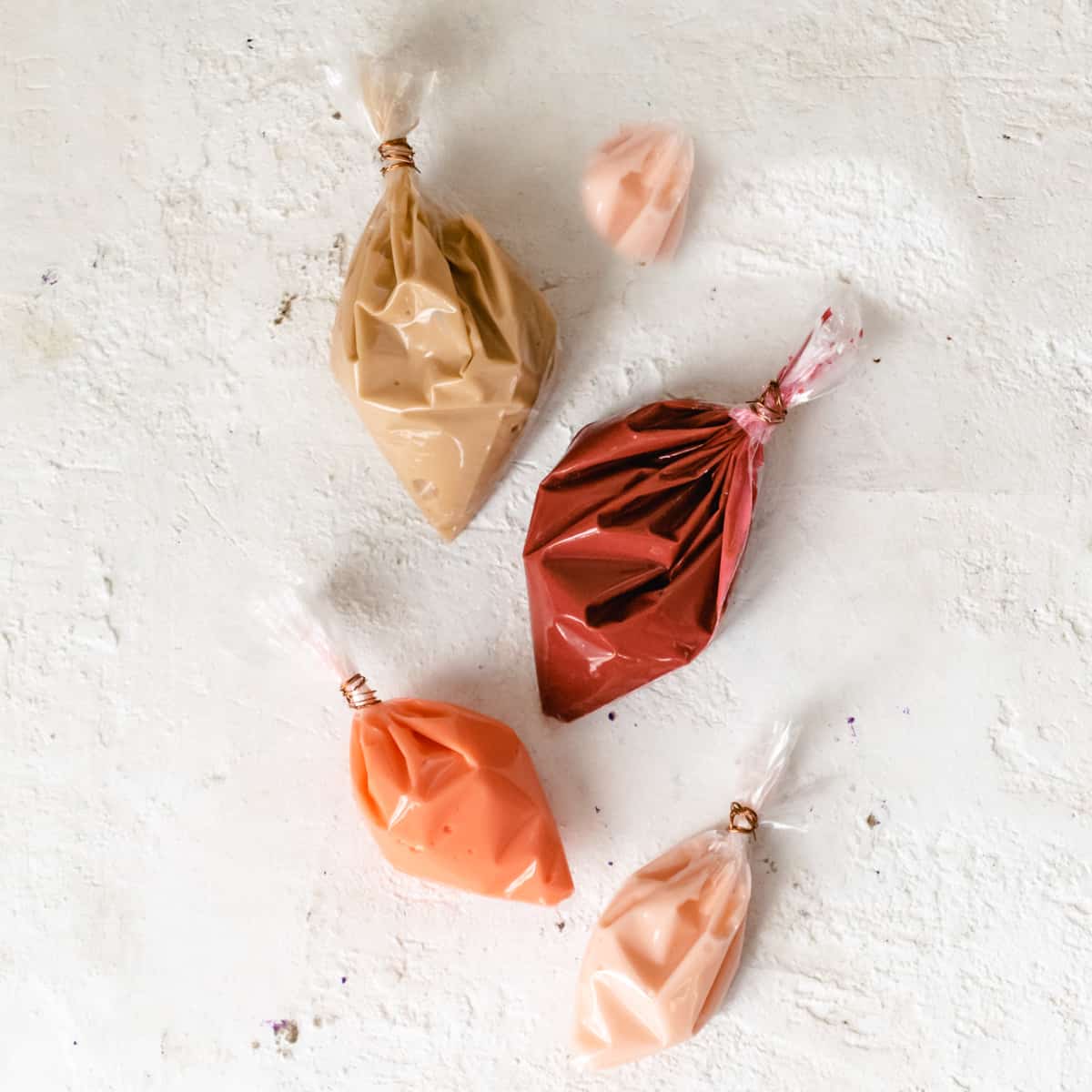 Four bags filled with the sprinkle mixture recipe in shades of pink.